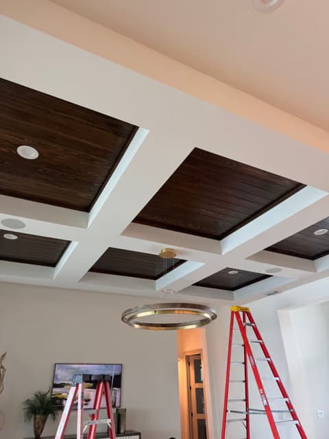Techo de vigas de madera con casetones e iluminación empotrada instalada en una renovación de sala