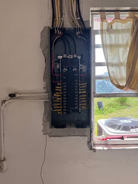 Panel eléctrico con los interruptores expuestos y cableado nuevo durante una actualización