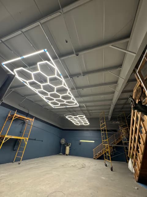Lámpara LED geométrica tipo panal instalada en el techo de un garaje