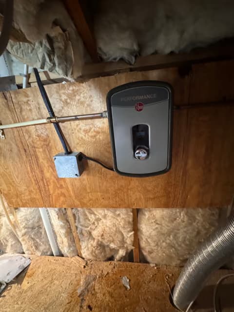 Calentador de agua sin tanque montado entre los postes de la pared durante la instalación