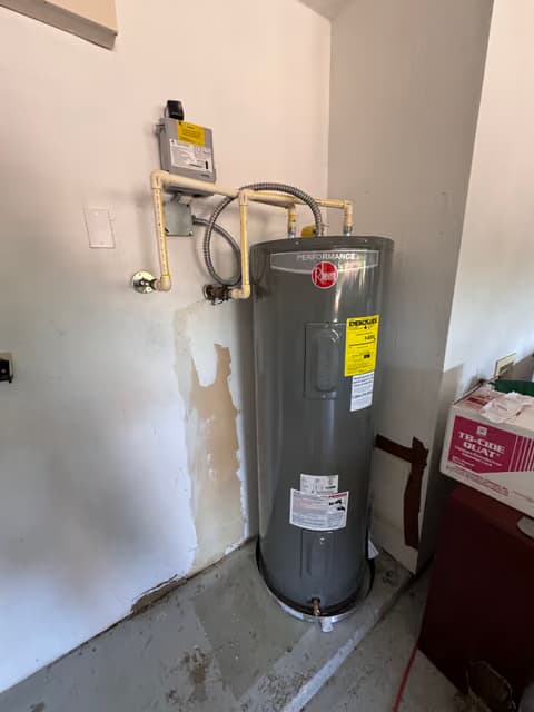 Calentador de agua de tanque tradicional instalado en un clóset de servicio