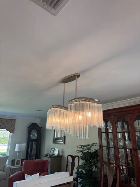 Candelabro de cristal de varios niveles instalado sobre una mesa de comedor