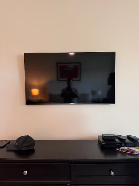 Televisor de pantalla plana montado en la pared sobre un mueble multimedia