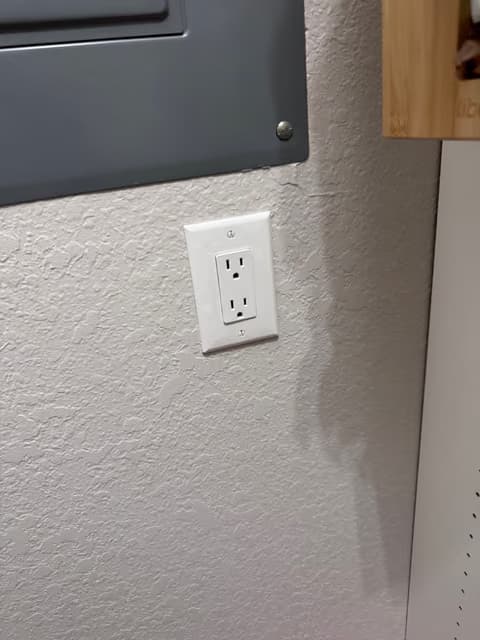 Nuevo tomacorriente instalado en una pared interior texturizada