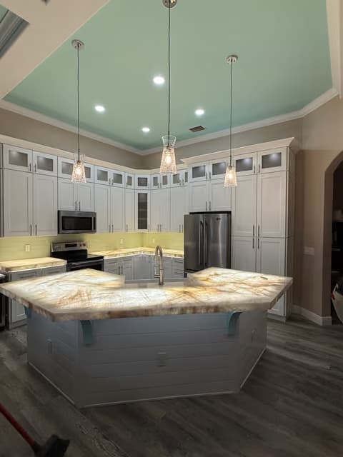 Cocina con iluminación colgante sobre la isla y azulejo decorativo