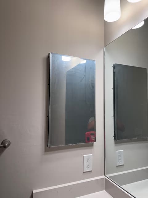Espejo de baño y lámpara de tocador instalados sobre un lavabo
