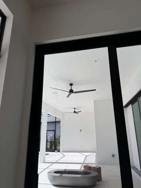 Terraza cerrada con un nuevo ventilador de techo y puertas de vidrio