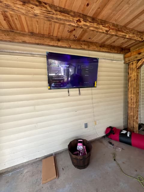 Televisor montado en el techo de madera de un porche