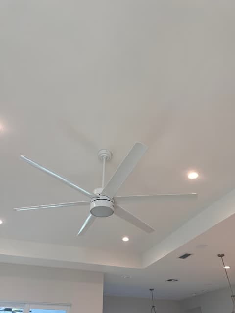 Ventilador de techo grande instalado en un techo tipo bandeja con iluminación empotrada