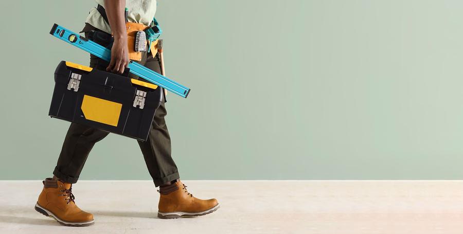 KirchCo handyman carrying a toolbox and level, ready for the next job